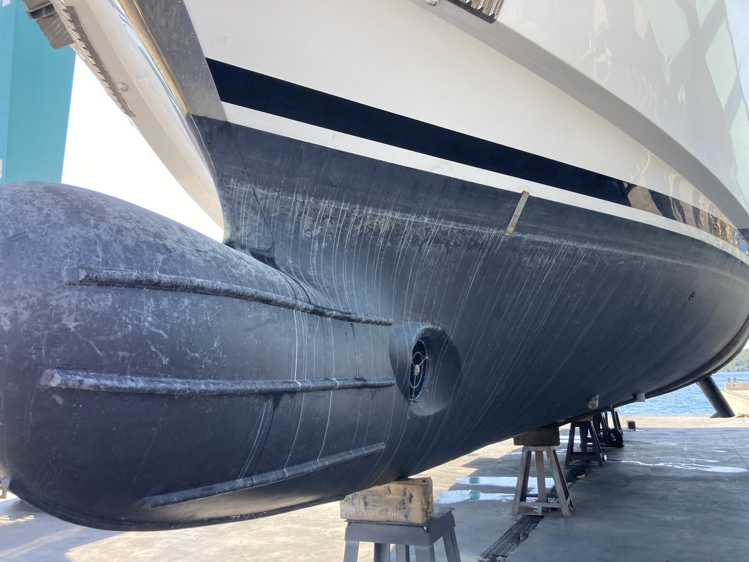 The bulbous bow of a superyacht when being surveyed on a shipyard hardstand